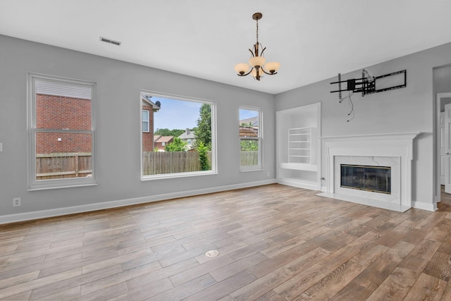 5000 Loch Lorne Ct, Mount Juliet, TN 37122 - unfurnished living room with a chandelier, light wood-type flooring, a premium fireplace, and built in shelves