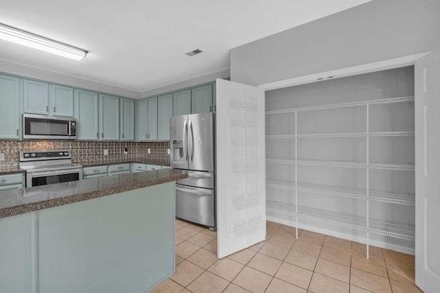 5000 Loch Lorne Ct, Mount Juliet, TN 37122 - kitchen with stainless steel appliances, light tile patterned floors, blue cabinets, tasteful backsplash, and dark stone countertops