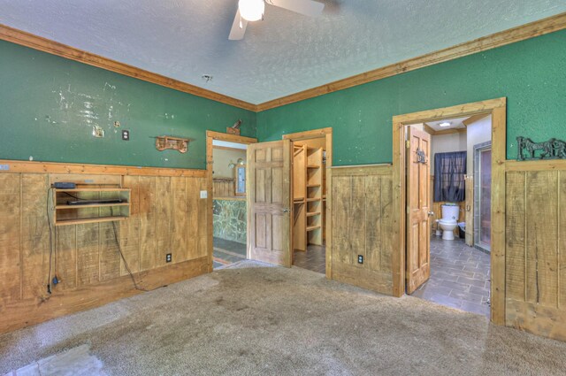 417 Haskins Chapel Rd, Lewisburg, TN 37091 - unfurnished bedroom with a textured ceiling, wainscoting, crown molding, wooden walls, and a walk in closet