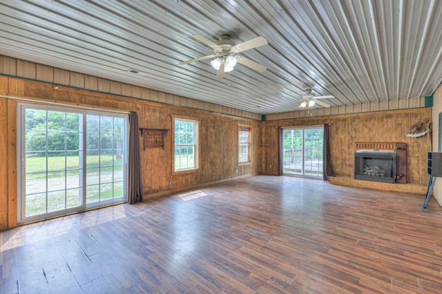 417 Haskins Chapel Rd, Lewisburg, TN 37091 - unfurnished living room featuring wood walls, ceiling fan, wood finished floors, and a fireplace with raised hearth