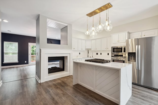 127 Carriage Ct, Brentwood, TN 37027 - kitchen featuring stainless steel appliances, a center island, white cabinetry, wood finished floors, and a sink