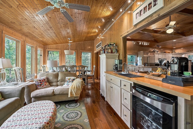 2541 Sparkmantown Rd, Doyle, TN 38559 - living room with a ceiling fan, beverage cooler, wood ceiling, wooden walls, and dark wood-type flooring