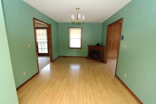 680 Oak Grove Rd, Goodspring, TN 38460 - unfurnished living room with a chandelier, light wood-style flooring, a fireplace, and baseboards
