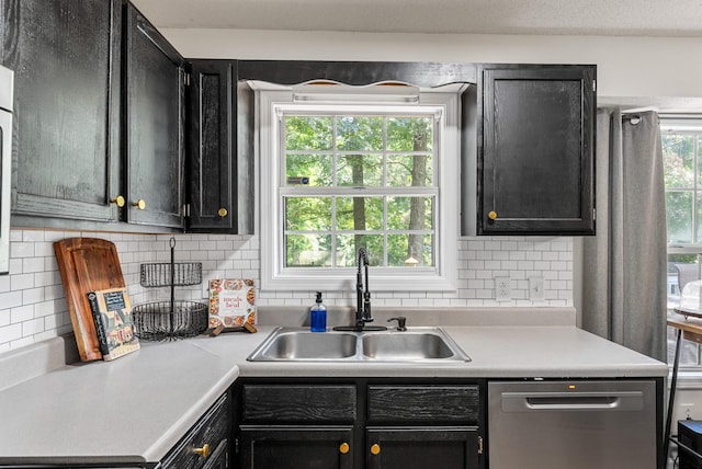 2930 Charlie Sleigh Rd, Woodlawn, TN 37191 - kitchen with stainless steel dishwasher, dark cabinets, light countertops, and tasteful backsplash