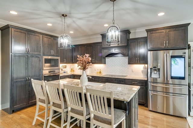 1105 Kittywood Ct, Murfreesboro, TN 37129 - kitchen featuring stainless steel appliances, ornamental molding, dark brown cabinets, light stone counters, and pendant lighting