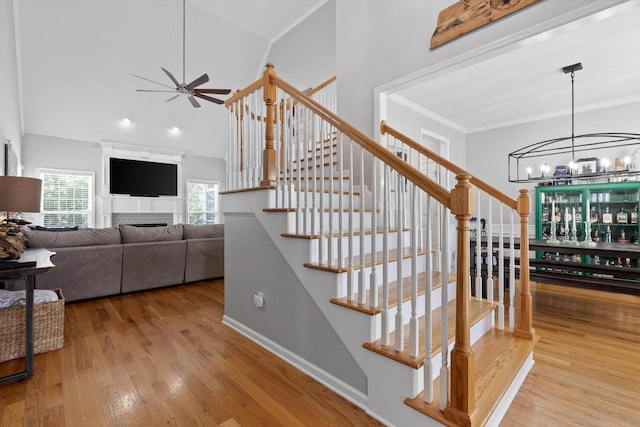 6523 Brigade Ln, Hixson, TN 37343 - staircase featuring a ceiling fan, wood finished floors, a chandelier, a fireplace, and crown molding