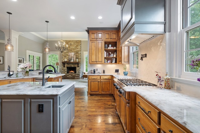 8255 Jamie Ct, Brentwood, TN 37027 - kitchen featuring dark wood-style floors, a sink, stainless steel gas stovetop, a stone fireplace, and ornamental molding