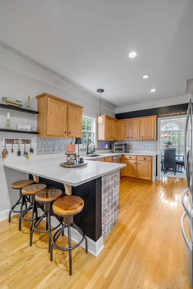 2988 Barnstable Ct, Murfreesboro, TN 37127 - kitchen featuring a peninsula, ornamental molding, light countertops, a sink, and a kitchen breakfast bar
