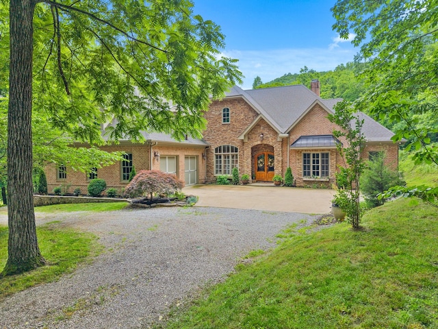 6779 Arno Allisona Rd, College Grove, TN 37046 - view of front facade featuring concrete driveway, brick siding, an attached garage, a chimney, and a front lawn