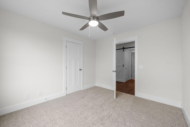 1573 Collins View Way, Clarksville, TN 37043 - unfurnished bedroom featuring carpet floors, baseboards, a barn door, and ceiling fan