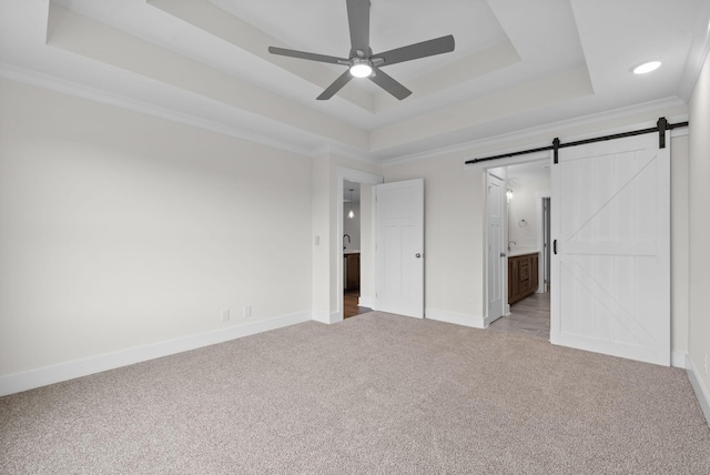 1573 Collins View Way, Clarksville, TN 37043 - unfurnished bedroom with light colored carpet, a tray ceiling, a barn door, baseboards, and ensuite bath