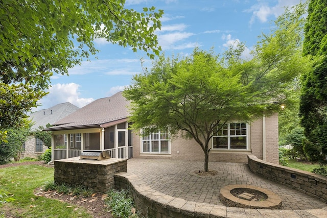 286 Keswick Grove Ln, Franklin, TN 37067 - rear view of house featuring a sunroom, a patio, brick siding, an outdoor fire pit, and a shingled roof