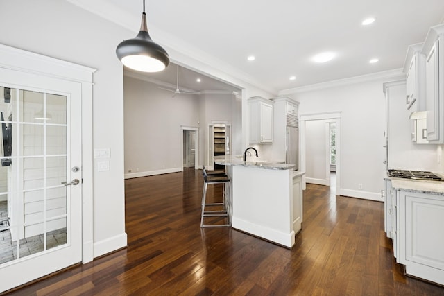 286 Keswick Grove Ln, Franklin, TN 37067 - kitchen with ornamental molding, white cabinets, dark wood finished floors, a peninsula, and recessed lighting