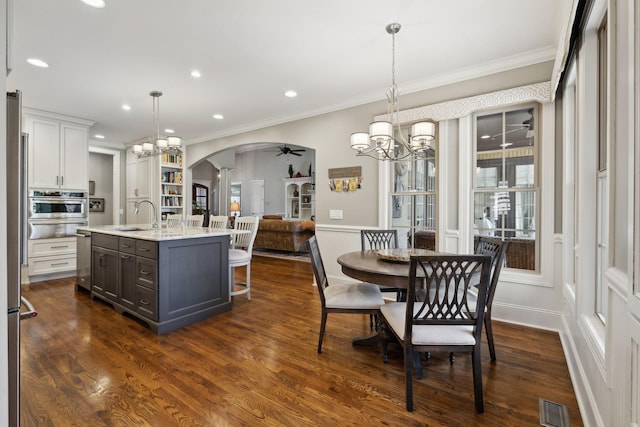 1194 Meadow Bridge Ln, Arrington, TN 37014 - dining space with a chandelier, ceiling fan, arched walkways, ornamental molding, and dark wood-style flooring