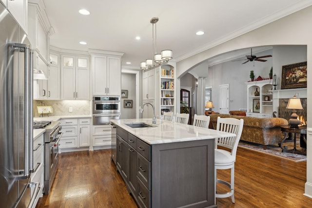1194 Meadow Bridge Ln, Arrington, TN 37014 - kitchen with a sink, arched walkways, ceiling fan, white cabinets, and a warming drawer