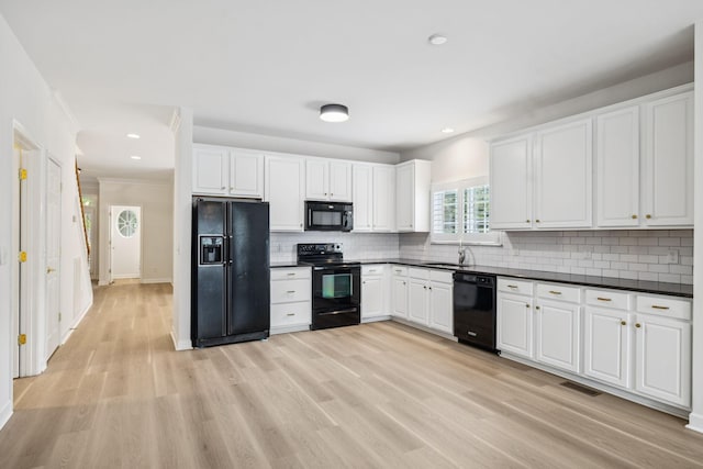 1906 Montgomery Way, Franklin, TN 37067 - kitchen featuring black appliances, dark countertops, light wood finished floors, decorative backsplash, and white cabinets