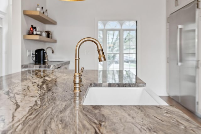 205 Well Spring Ct, Brentwood, TN 37027 - kitchen view of stone countertops, a sink, high end fridge, and open shelves