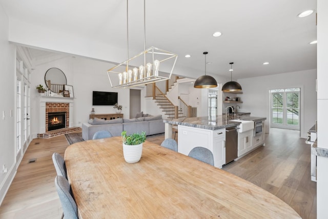 205 Well Spring Ct, Brentwood, TN 37027 - dining area with stairway, light wood-type flooring, recessed lighting, a brick fireplace, and baseboards