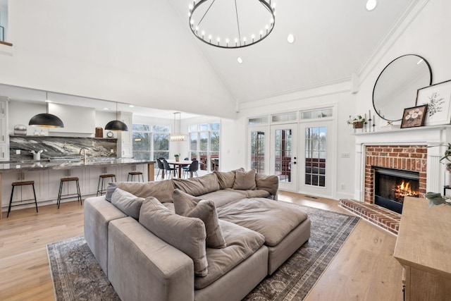 205 Well Spring Ct, Brentwood, TN 37027 - living room featuring high vaulted ceiling, light wood finished floors, recessed lighting, a brick fireplace, and a chandelier