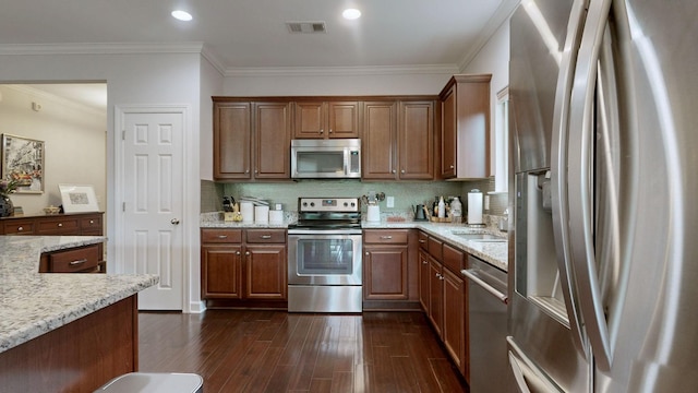 1740 Hartford Ln, Mount Juliet, TN 37122 - kitchen featuring appliances with stainless steel finishes, dark wood finished floors, light stone counters, crown molding, and tasteful backsplash