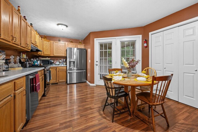 114 Silver Leaf Cir, Dickson, TN 37055 - kitchen with appliances with stainless steel finishes, light countertops, dark wood finished floors, brown cabinetry, and under cabinet range hood