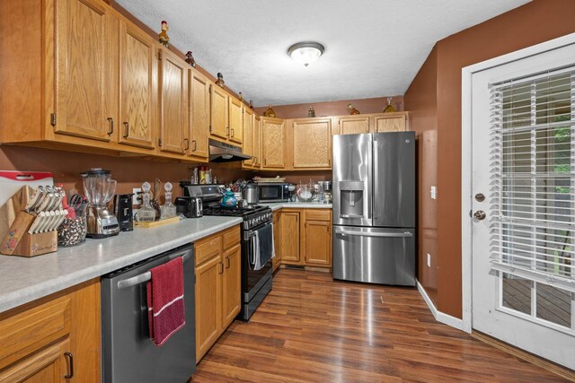 114 Silver Leaf Cir, Dickson, TN 37055 - kitchen with appliances with stainless steel finishes, light countertops, under cabinet range hood, and dark wood-style floors