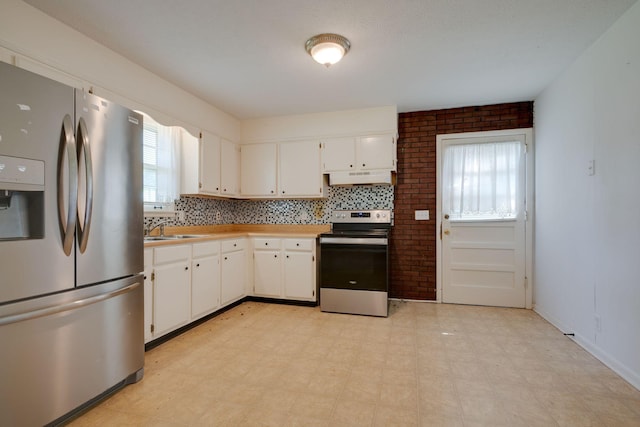 7703 Horn Tavern Rd, Fairview, TN 37062 - kitchen featuring appliances with stainless steel finishes, under cabinet range hood, light floors, and white cabinetry