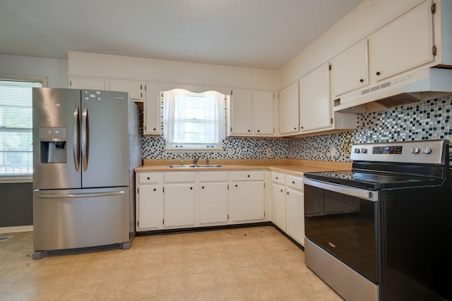 7703 Horn Tavern Rd, Fairview, TN 37062 - kitchen with stainless steel appliances, under cabinet range hood, light countertops, and decorative backsplash