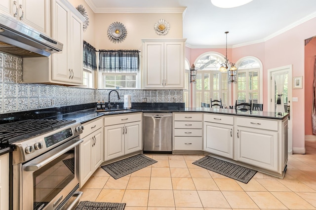 673 Newton Ln, Gallatin, TN 37066 - kitchen featuring stainless steel appliances, under cabinet range hood, a chandelier, backsplash, and ornamental molding