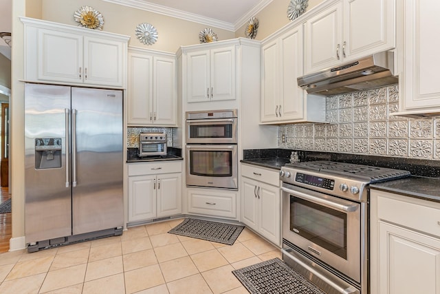 673 Newton Ln, Gallatin, TN 37066 - kitchen featuring appliances with stainless steel finishes, under cabinet range hood, crown molding, dark countertops, and white cabinetry
