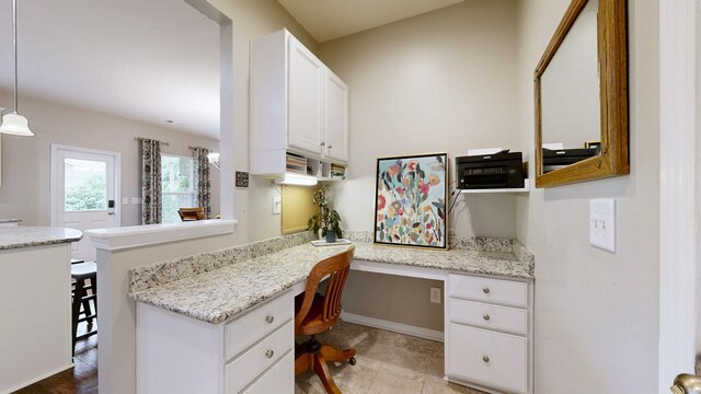 2809 Kaye Dr, Thompsons Station, TN 37179 - kitchen with built in study area, white cabinetry, a peninsula, and light stone countertops