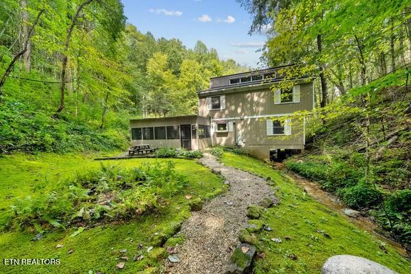 3127 Emerald Springs Loop, Sevierville, TN 37862 - rear view of house featuring a sunroom and a wooded view