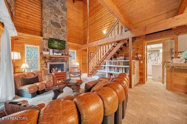 3127 Emerald Springs Loop, Sevierville, TN 37862 - living area featuring wood walls, high vaulted ceiling, wood ceiling, a fireplace, and light colored carpet