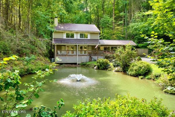 3127 Emerald Springs Loop, Sevierville, TN 37862 - rear view of property featuring a chimney, a forest view, and metal roof