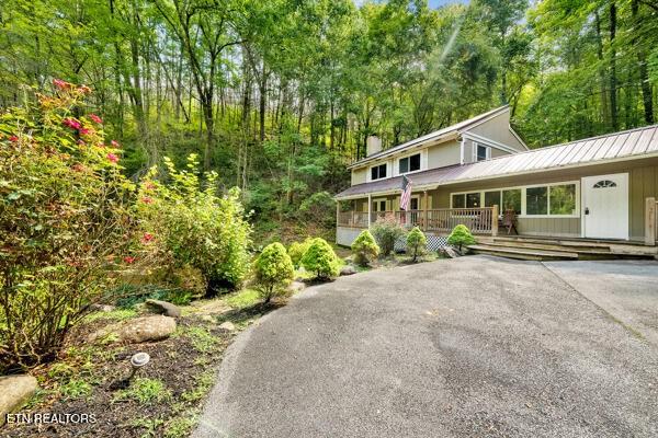 3127 Emerald Springs Loop, Sevierville, TN 37862 - view of front facade with a chimney, metal roof, and a porch
