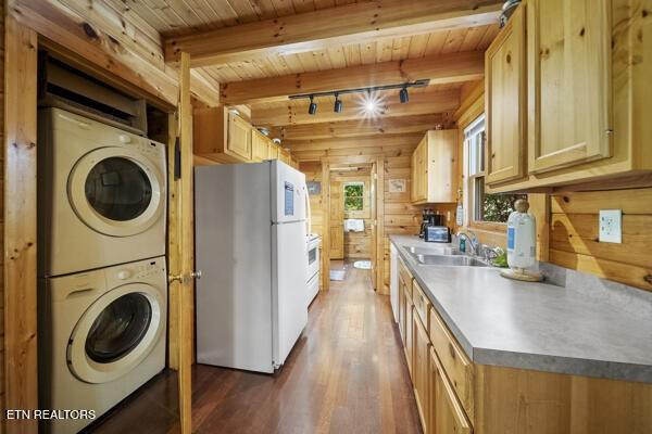 4196 Mountain Rest Way, Sevierville, TN 37876 - kitchen featuring white appliances, estacked washer and dryer, wooden ceiling with exposed beams, dark wood-type flooring, and a sink