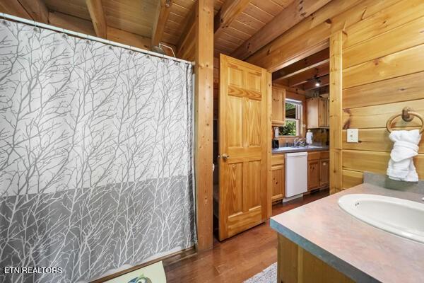 4196 Mountain Rest Way, Sevierville, TN 37876 - bathroom featuring vanity, wooden ceiling with exposed beams, wooden walls, wood finished floors, and curtained shower