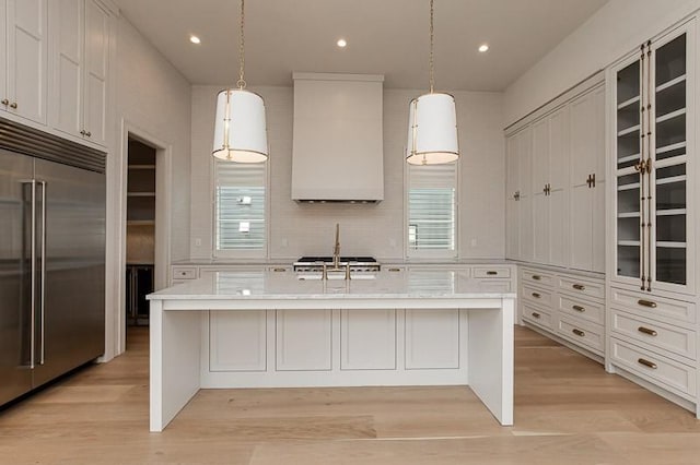 1302B Pillow St, Nashville, TN 37203 - kitchen with built in fridge, custom range hood, white cabinets, a center island with sink, and glass insert cabinets