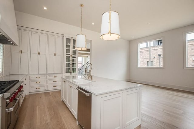 1302B Pillow St, Nashville, TN 37203 - kitchen with stainless steel dishwasher, a sink, light wood-style floors, custom range hood, and white cabinets