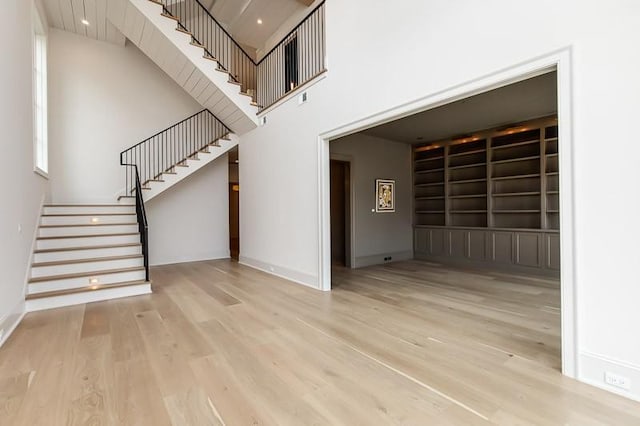 1302B Pillow St, Nashville, TN 37203 - unfurnished living room featuring wood finished floors, stairway, baseboards, a high ceiling, and built in features