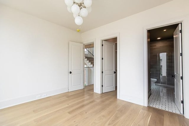 1302B Pillow St, Nashville, TN 37203 - unfurnished bedroom featuring a chandelier, light wood-style flooring, baseboards, and ensuite bath