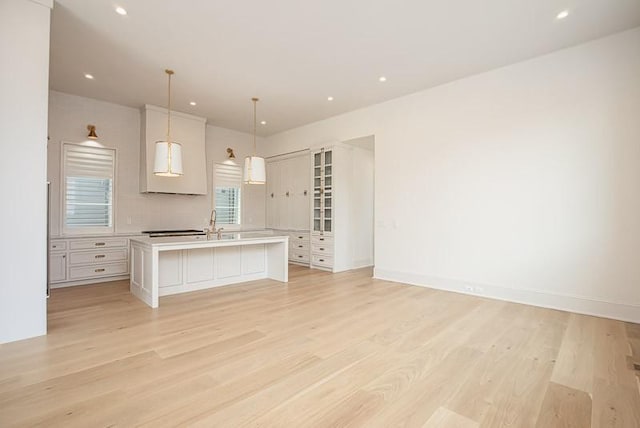 1302B Pillow St, Nashville, TN 37203 - kitchen with light countertops, a center island with sink, light wood-style flooring, open floor plan, and pendant lighting