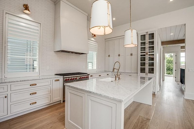 1302B Pillow St, Nashville, TN 37203 - kitchen with high end stainless steel range oven, a sink, light wood finished floors, custom exhaust hood, and light stone countertops