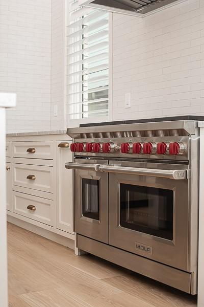 1302B Pillow St, Nashville, TN 37203 - kitchen view of range with two ovens, light countertops, white cabinets, light wood finished floors, and extractor fan