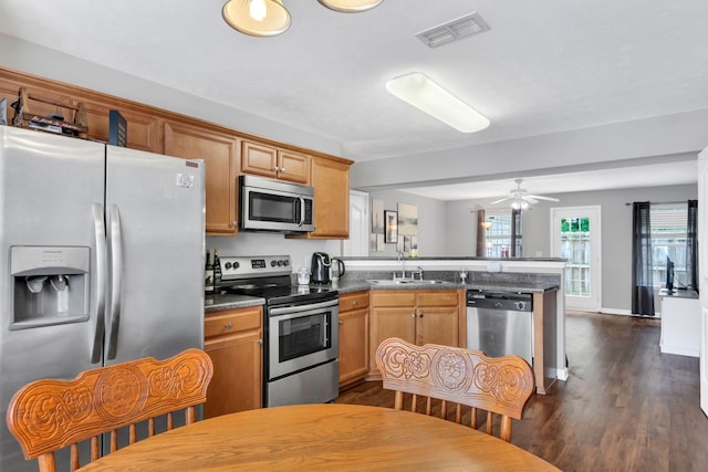 243 Shoshone Pl, Murfreesboro, TN 37128 - kitchen with stainless steel appliances, a peninsula, dark wood finished floors, ceiling fan, and dark countertops