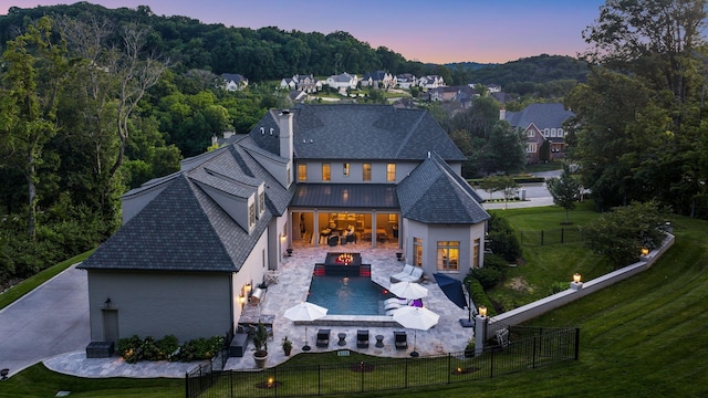 1024 Vaughn Crest Dr, Franklin, TN 37069 - rear view of property featuring a fenced backyard, a standing seam roof, a patio, a metal roof, and stucco siding