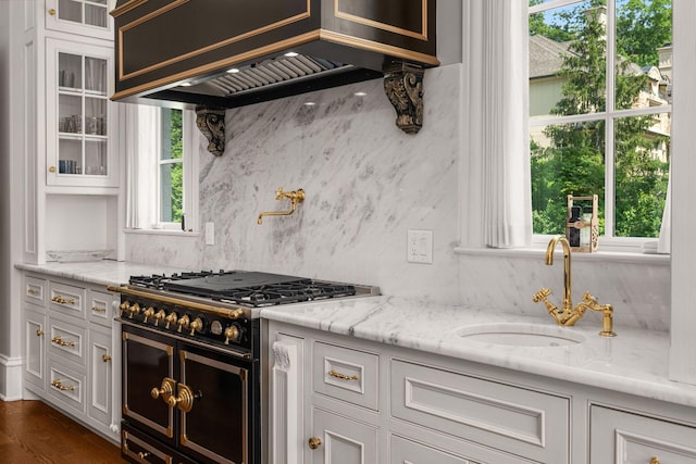 1024 Vaughn Crest Dr, Franklin, TN 37069 - kitchen featuring double oven range, custom range hood, glass insert cabinets, white cabinets, and light stone counters