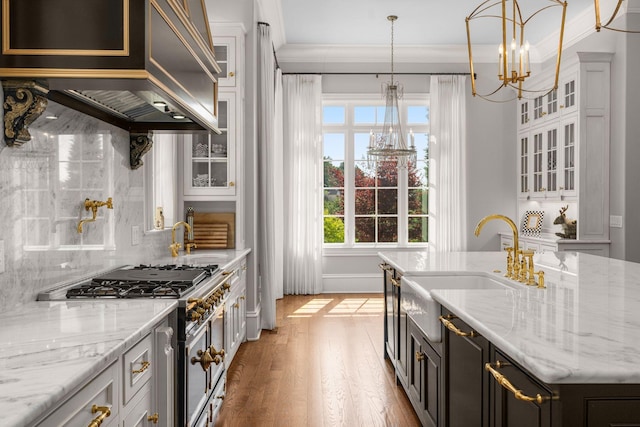 1024 Vaughn Crest Dr, Franklin, TN 37069 - kitchen with high end stainless steel range, a chandelier, light wood finished floors, white cabinets, and crown molding