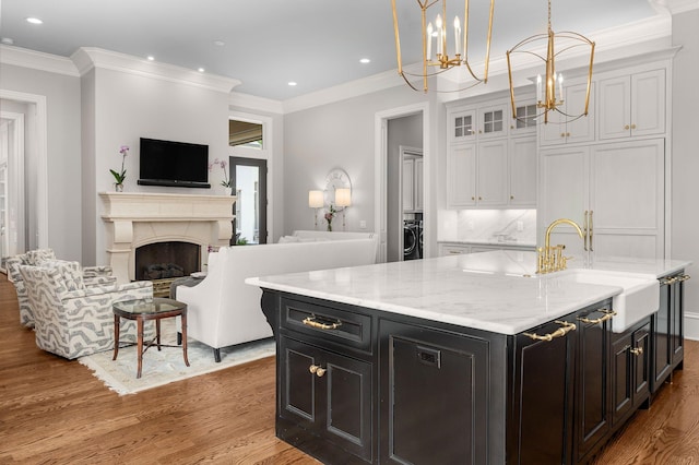 1024 Vaughn Crest Dr, Franklin, TN 37069 - kitchen featuring wood finished floors, a chandelier, open floor plan, ornamental molding, and white cabinets