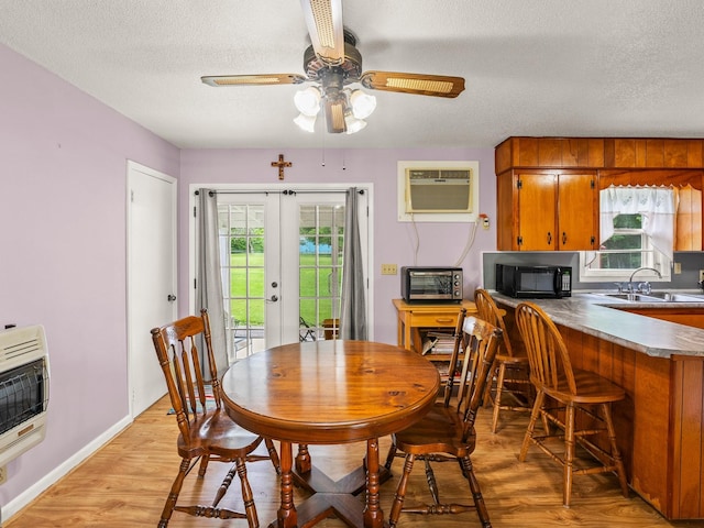 1544 Midway Rd, Sewanee, TN 37375 - dining room featuring a wall mounted AC, french doors, a textured ceiling, heating unit, and light wood-style floors